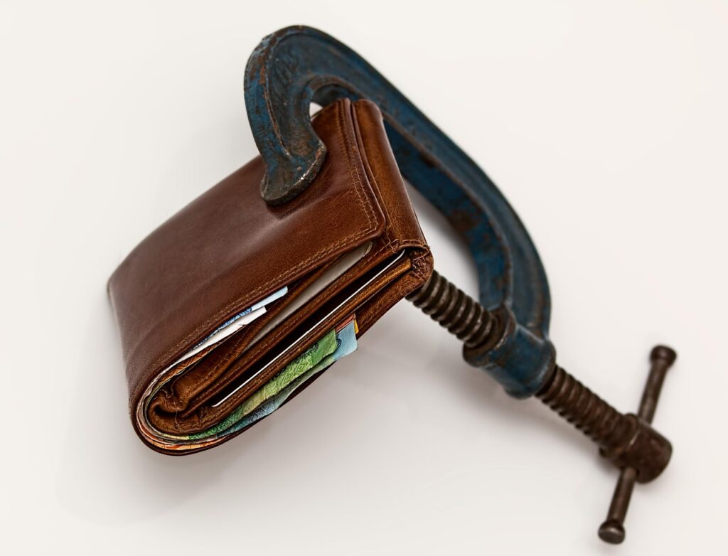 A clamp on a wallet to symbolize debt